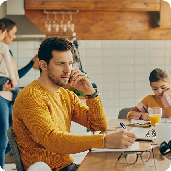 Man on phone with family around